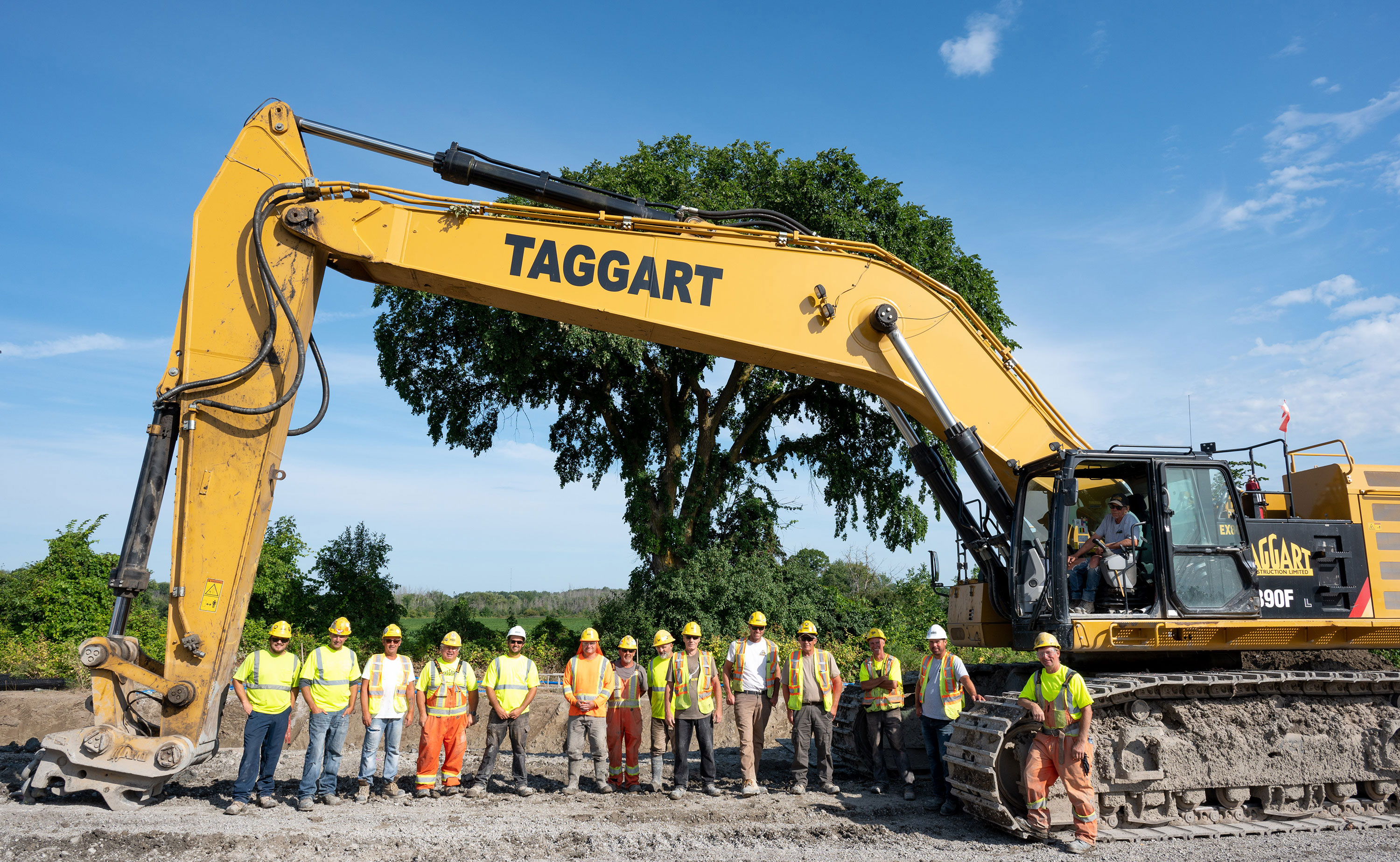 Photograph of construction team posing with heavy machinery